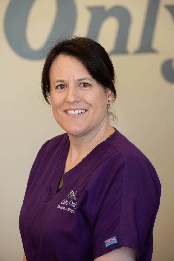Smiling staff member in purple scrubs at Cats Only Veterinary Hospital